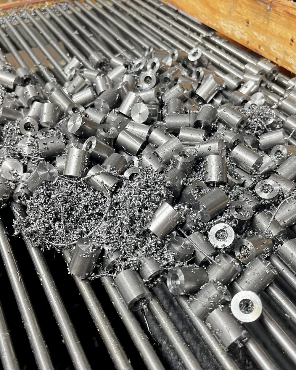 Freshly turned steel bushes among metal swarf