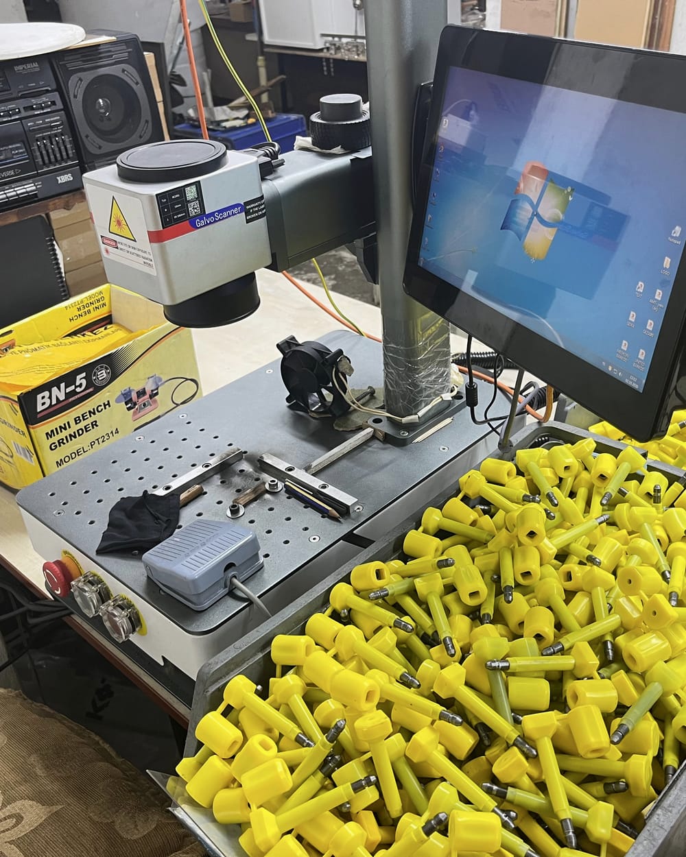 Laser marking station beside crates of yellow bolt seals